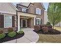 Inviting front porch with elegant columns, detailed brickwork, and mature landscaping at 2100 Baywood Sw Blvd, Austell, GA 30106