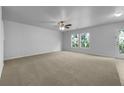 Spacious living room with plush carpeting, large windows, ceiling fan, and patio door at 325 Freeman Cir, Villa Rica, GA 30180