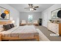 Bright main bedroom featuring a queen bed, ceiling fan, and a view of the neighborhood at 325 Freeman Cir, Villa Rica, GA 30180