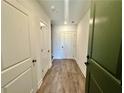 Entryway with wood-look flooring leading to doors; green front door on right at 546 Sawnee Village Blvd # D71, Cumming, GA 30040