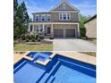 Beautiful two-story home with stone and siding, a front porch and an in-ground pool and spa at 526 Lost Creek Dr, Woodstock, GA 30188
