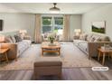Bright living room features neutral furniture, wood-look flooring, and large windows for plenty of natural light at 5790 Ivywood Dr, Lithonia, GA 30038