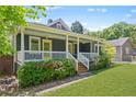Inviting home featuring a covered porch adorned with colorful flowers, wooden steps, and a well-maintained lawn at 873 United Se Ave, Atlanta, GA 30312