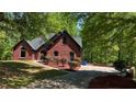 Charming brick home with a manicured lawn, mature trees, and a spacious driveway at 225 Austin Oaks Se Dr, Ellenwood, GA 30294