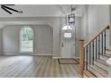 Bright foyer with wood stairs, luxury vinyl plank flooring and decorative chandelier at 5825 Rolling Oaks Dr, Cumming, GA 30040
