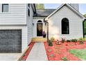 Close up of the home's front door with colorful flowerbed, fresh mulch and walkway at 5825 Rolling Oaks Dr, Cumming, GA 30040