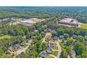 Aerial view of a neighborhood showcasing schools amid lush greenery and tree coverage at 2325 Walnut Grove Way, Suwanee, GA 30024