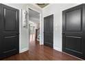 Hallway featuring hardwood floors, stylish black doors, and elegant trim work, creating a welcoming atmosphere at 3709 Baxley Ridge Dr, Suwanee, GA 30024