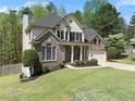 Beautiful two-story home with brick and vinyl siding, a two-car garage, and landscaped front yard at 7665 Golden Sands Dr, Cumming, GA 30041