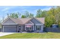 Inviting exterior showcasing a gray home with a stone-accented garage and a cozy front patio area at 12 Little Creek Manor Dr, Dallas, GA 30157