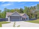 Beautiful home with a gray exterior, a well-maintained lawn, and a spacious driveway at 12 Little Creek Manor Dr, Dallas, GA 30157