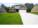 A cozy single-story house featuring lush green lawn, a driveway, and pleasant landscaping details at 142 Susie Creek Ln, Villa Rica, GA 30180