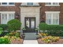 Elegant building entrance with manicured landscaping, detailed stonework, and classic lanterns at 20 Collier Nw Rd # 11, Atlanta, GA 30309