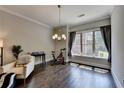 Bright living room with hardwood floors, large window, modern chandelier, and neutral wall colors at 1372 Doublegate Dr, Atlanta, GA 30319