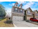 Lovely townhome featuring a two-car garage with a double wide driveway and attractive architectural details at 2722 Sardis Chase Ct, Buford, GA 30519