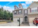 Beautiful townhome featuring a two-car garage, welcoming entrance, and manicured landscaping at 2722 Sardis Chase Ct, Buford, GA 30519