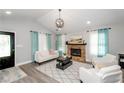 Cozy living room with stone fireplace, modern lighting, and comfortable seating arrangement at 238 Knob Hill Dr, Locust Grove, GA 30248