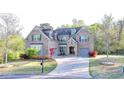 Charming brick home with a well-manicured lawn and a curved driveway at 4155 Winterberry Rd, Cumming, GA 30040