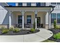 Charming front porch with seating, lush landscaping, and a welcoming walkway to the front door at 105 Aspen Hall Dr, Canton, GA 30115