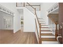 Bright foyer showcasing hardwood floors, white staircase with wood trim, and open floor plan at 18 Rose Gate Ne Dr, Atlanta, GA 30342