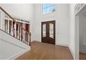 Inviting foyer with a view of the front door and two-story window, hardwood floors, and white trim at 18 Rose Gate Ne Dr, Atlanta, GA 30342