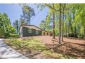 A beautiful home sits on a wooded lot with a long driveway and grass at 3350 Pine Meadow Nw Rd, Atlanta, GA 30327
