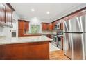 Traditional kitchen with granite countertops, wood cabinets, stainless steel appliances, and wine fridge at 171 Riverview Trl, Roswell, GA 30075