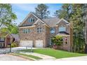 Charming brick home with a two-car garage, lush lawn, and mature trees in a lovely neighborhood at 360 Beracah Sw Trl, Atlanta, GA 30331