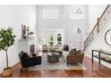 Bright living room features high ceilings, large windows, a fireplace, and stylish modern furniture at 360 Beracah Sw Trl, Atlanta, GA 30331