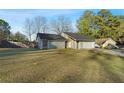 Exterior view of this lovely property from the side showing a large lawn and mature trees at 4657 Tartan Ct, Union City, GA 30291