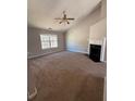 A spacious living room featuring high ceilings, a ceiling fan, fireplace and large windows at 8302 N Sterling Lakes Dr, Covington, GA 30014