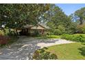 A ranch style home is pictured with a large magnolia tree and a sunny driveway and yard at 1911 Lavista Ne Rd, Atlanta, GA 30329