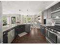 Modern kitchen with stainless steel appliances, dark cabinets, granite countertops, and hardwood floors at 1165 Evergreen Oak Way, Dacula, GA 30019