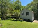 View of the home featuring a green lawn and mature trees at 861 Creek Nw Trl, Kennesaw, GA 30144