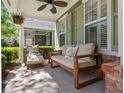 Inviting front porch with comfortable seating, ceiling fan, and hanging plants offers a relaxing outdoor space at 4510 Flowering Br, Powder Springs, GA 30127