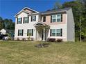 A two-story house features a green lawn, black shutters, and a combination of beige and tan exterior finishes at 205 Sullivan St, Hampton, GA 30228