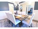 Elegant dining room with modern chandelier and white chairs surrounding a wooden table at 4881 Belle Estates Rd, Suwanee, GA 30024