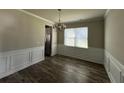 Elegant dining room featuring chair rail, chandelier lighting, and wood flooring at 231 Creek View Pl, Canton, GA 30114