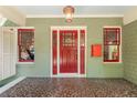 Close up of the charming red front door flanked by windows and stone porch floor at 374 8Th Ne St, Atlanta, GA 30309