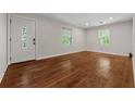 Bright living room with gleaming hardwood floors, fresh paint, and natural light streaming through the windows at 3690 Asbury Sw Ln, Atlanta, GA 30331