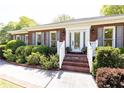 Close-up of home's brick porch, white trim and shutters, and lush landscaping at 4579 Blakedale Ne Cir, Roswell, GA 30075