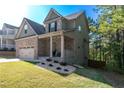 Side view of a two-story home showcasing the brick and siding exterior, lush lawn, and mature trees at 6424 Barker Station Walk, Sugar Hill, GA 30518