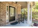 Close-up of the front porch featuring classic columns, rocking chairs, and a welcoming entrance at 6424 Barker Station Walk, Sugar Hill, GA 30518