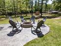 Outdoor stone firepit area with seating, perfect for entertaining and relaxing in a serene, wooded setting at 125 Mayo Rd, Covington, GA 30014