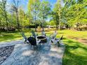 Lake property featuring an outdoor stone firepit area with seating and lovely views of the lake and surrounding woods at 125 Mayo Rd, Covington, GA 30014