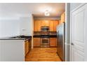 Well-equipped kitchen with stainless steel appliances, wood cabinets, and sleek black countertops at 375 Highland Ne Ave # 1011, Atlanta, GA 30312
