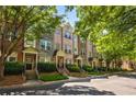 Row of townhomes featuring brick and stone exteriors, complemented by lush landscaping and mature trees at 1233 Ashford Creek Ne Park, Atlanta, GA 30319