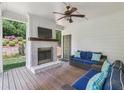 Inviting covered outdoor patio with a brick fireplace, wood plank ceiling, and comfortable seating at 1282 Fairhill Ne Ln, Atlanta, GA 30319