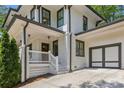 Beautiful white brick home featuring a side entry garage and inviting front porch with staircase entry at 1282 Fairhill Ne Ln, Atlanta, GA 30319