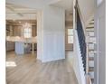 Inviting entryway with hardwood floors, staircase, and a view into the modern kitchen at 128 Felicity Pike, Locust Grove, GA 30248